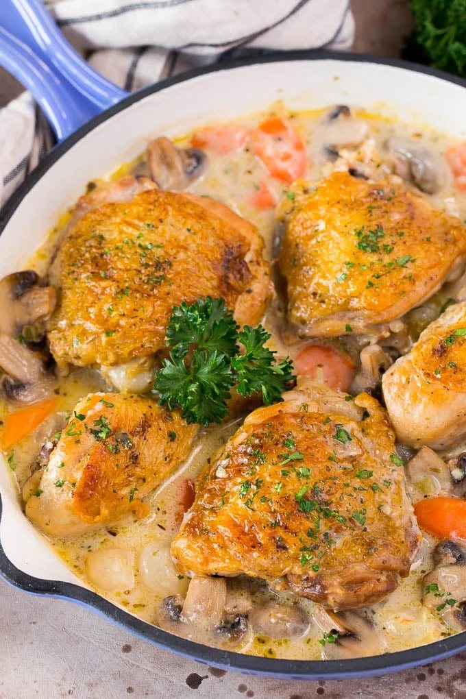 A pan of chicken fricassee in a silky sauce with vegetables.