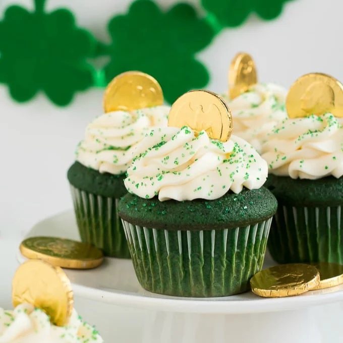 An image of several green velvet cupcakes on a platter.