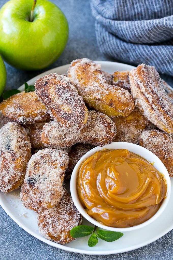 A pile of cinnamon sugar apple fries with caramel sauce for dipping.