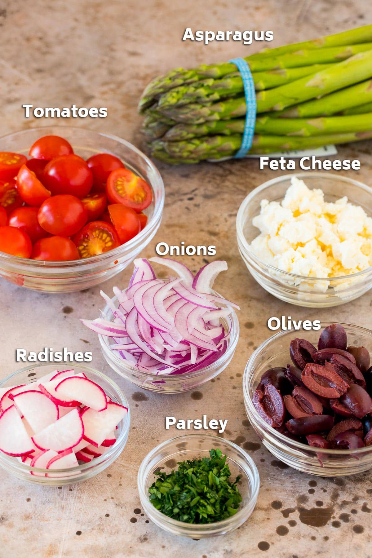 Bowls of vegetables, olives and cheese.