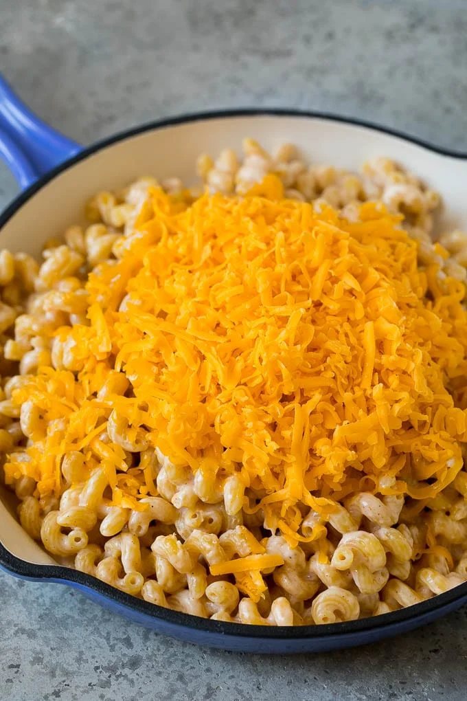 Pasta cooked in milk with shredded cheese on top.