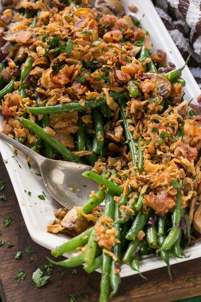 These green beans are cooked in a ranch butter sauce and topped with crispy onions and bacon. SO much better than green bean casserole!