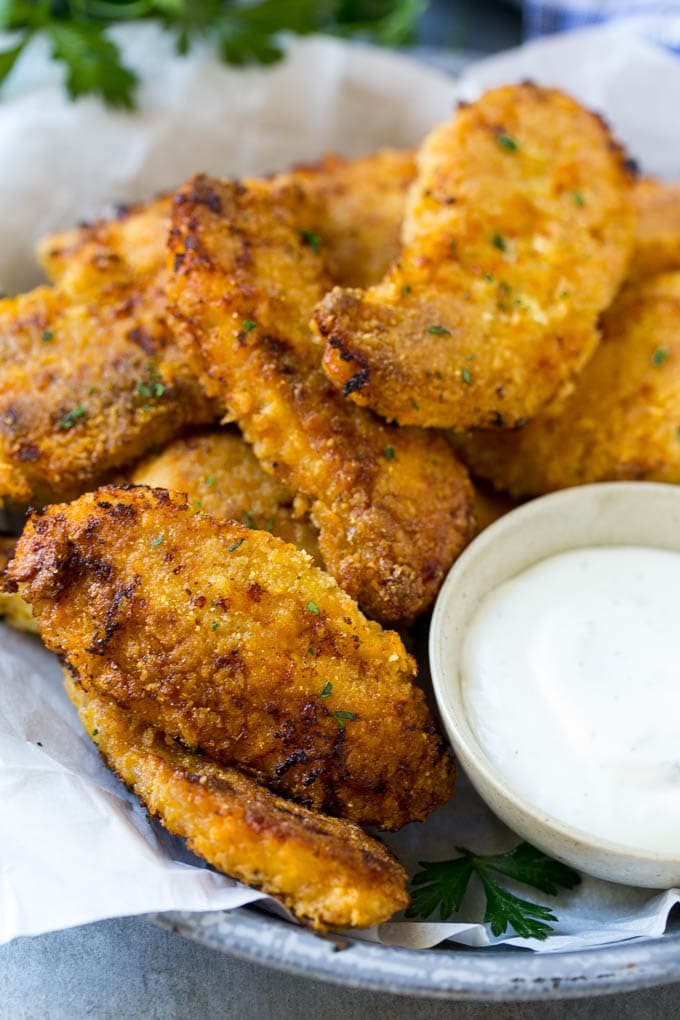 Crunchy baked fried chicken fingers on a plate with ranch dip.