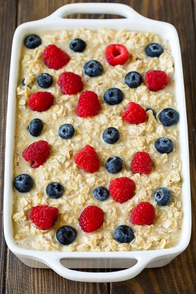 Oatmeal poured into a baking dish with berries on top.