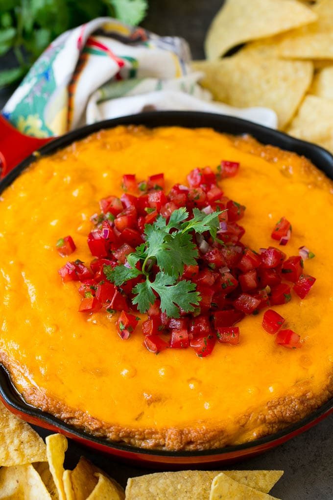 Cheesy Mexican bean dip topped with melted cheese and pico de gallo.