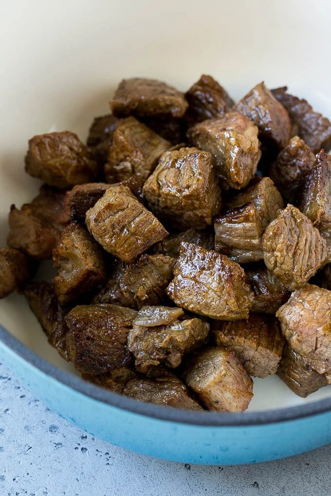 Seared stew meat in a large pot.