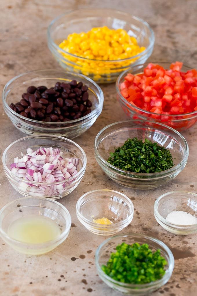 Bowls of ingredients including cilantro, corn, beans and tomatoes.
