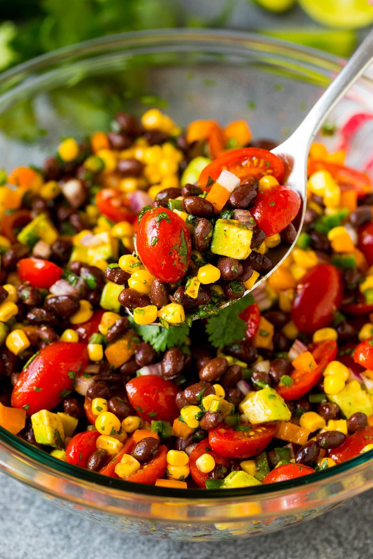 A serving spoon full of black bean salad.