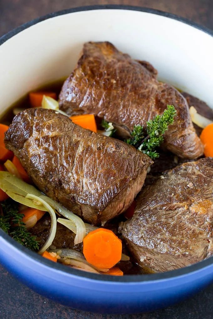 Short ribs with carrots and onions in a pot.