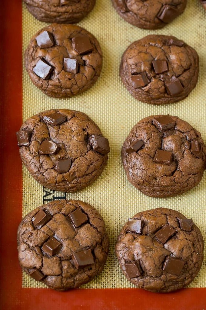Baked chocolate cookies on a sheet pan.