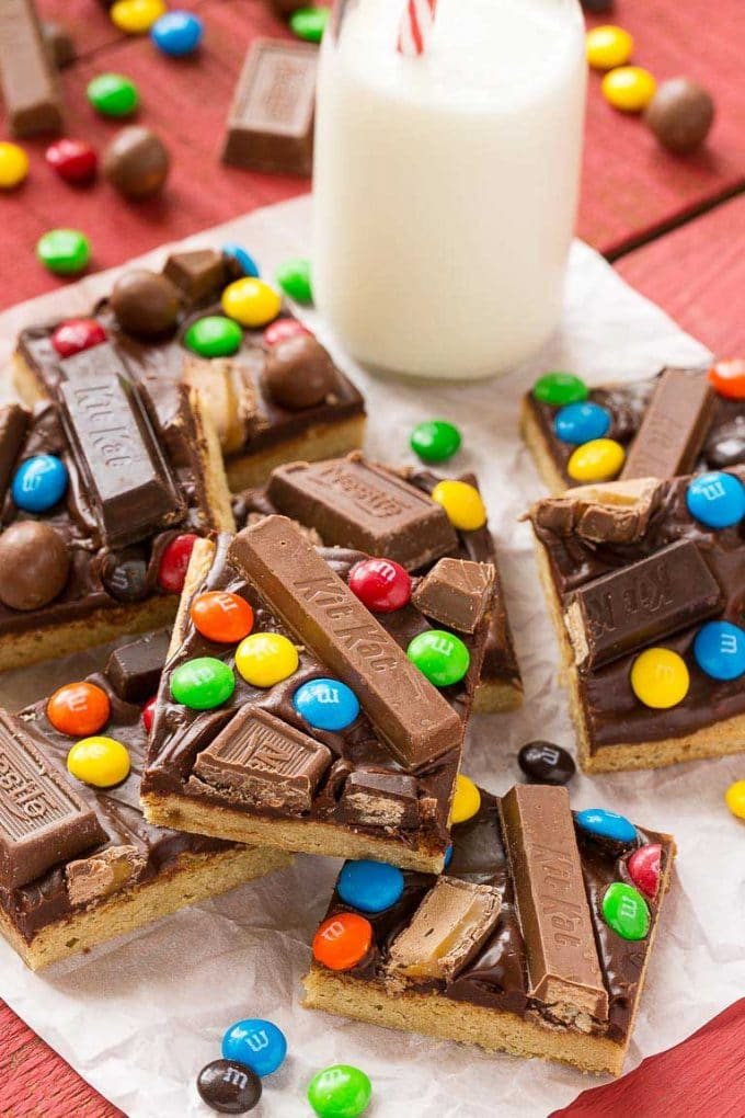 Candy bar blondies stacked on parchment paper.