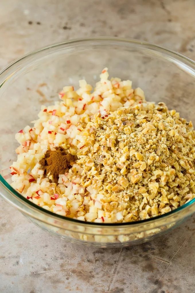 Apples, wine, cinnamon and honey all in a bowl.