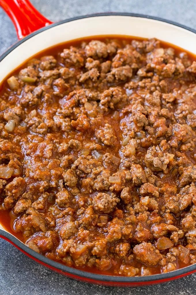 Ground beef, onions and tomato sauce in a skillet