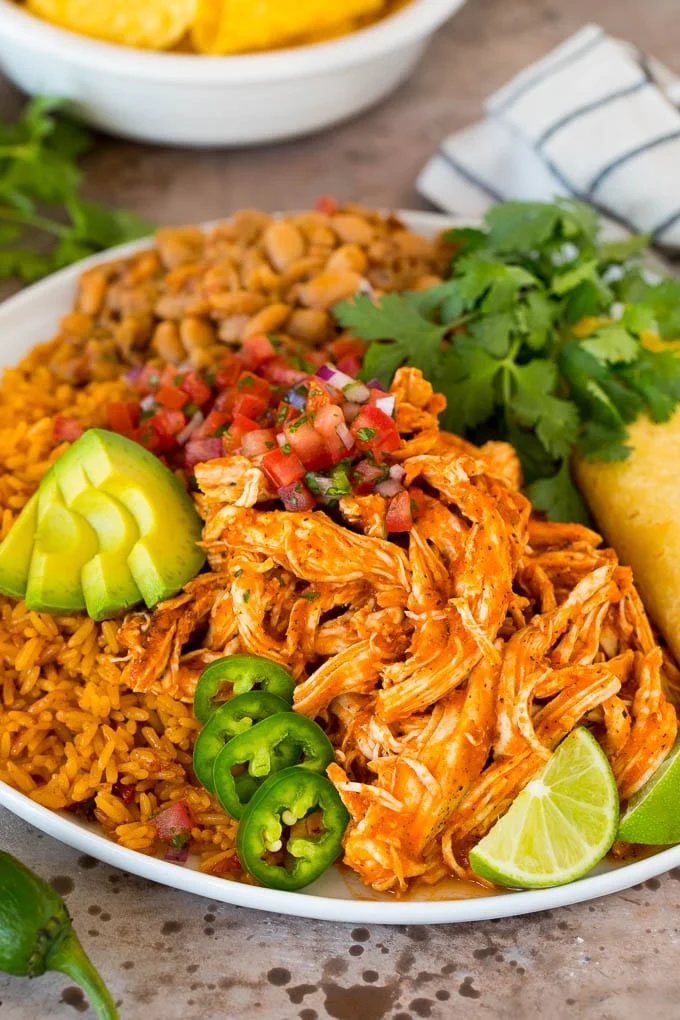 Chicken tinga served with rice, beans, avocado and salsa.