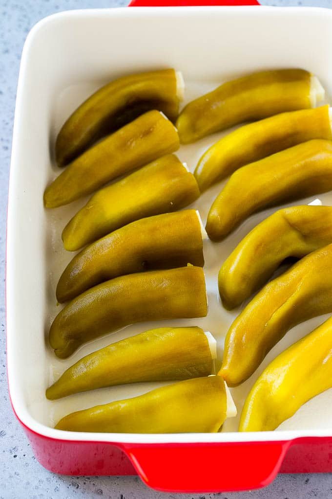 Cheese stuffed chiles in a baking dish.