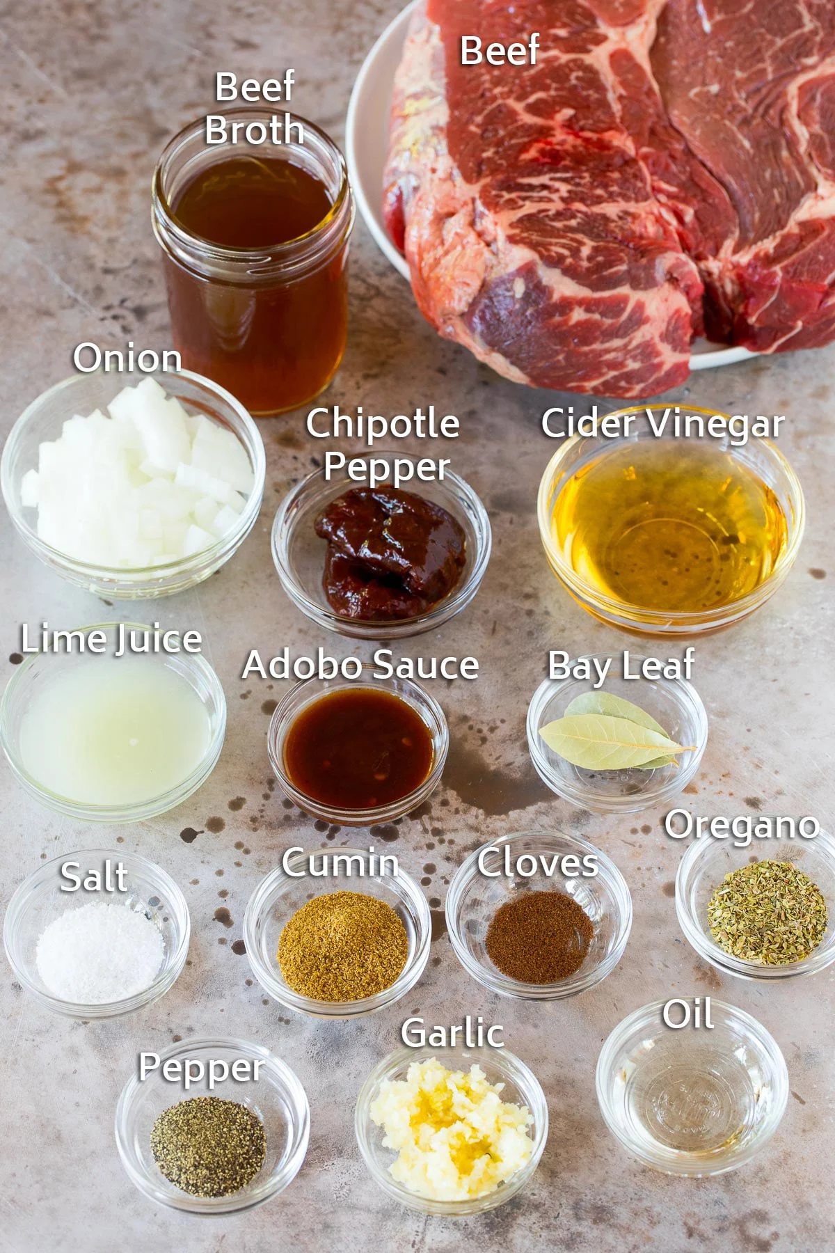 Bowls of different spices and seasonings, and a beef roast.