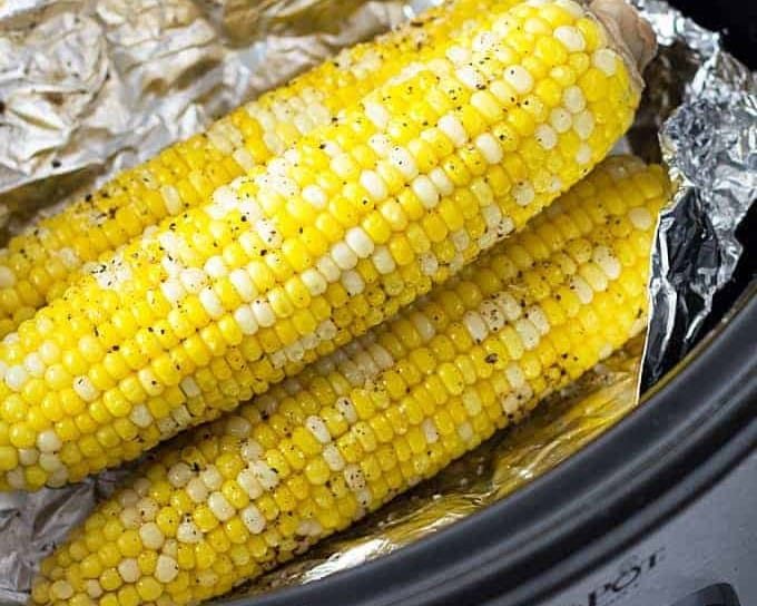 An image of ears of corn stacked in a slow cooker.