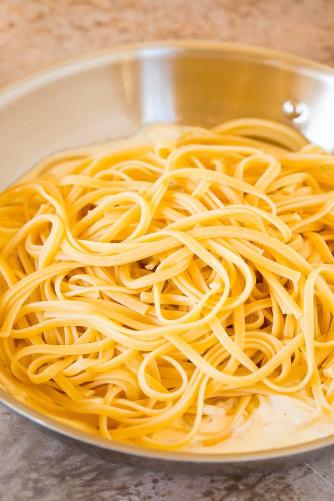 Linguine pasta on top of cream sauce.