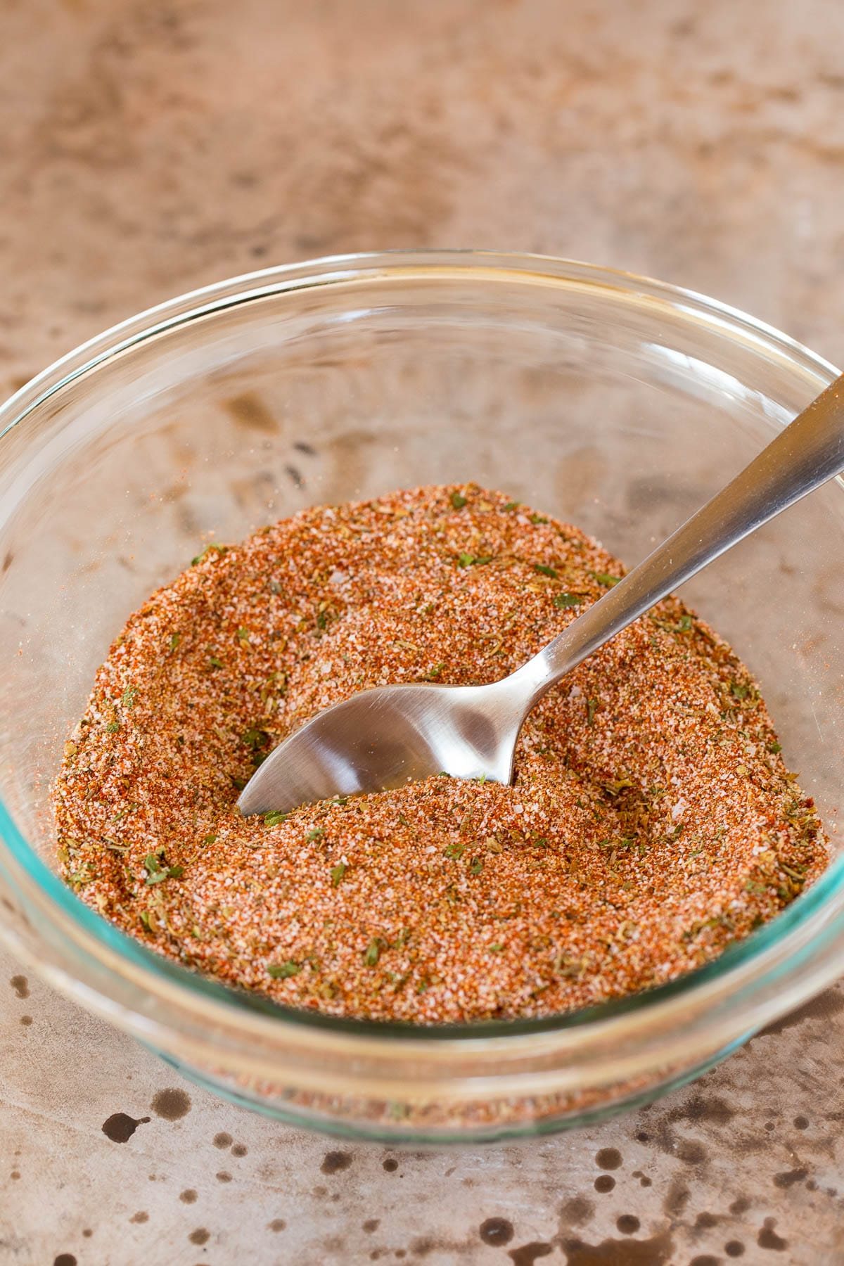 A bowl of seasoning blend with a spoon in it.