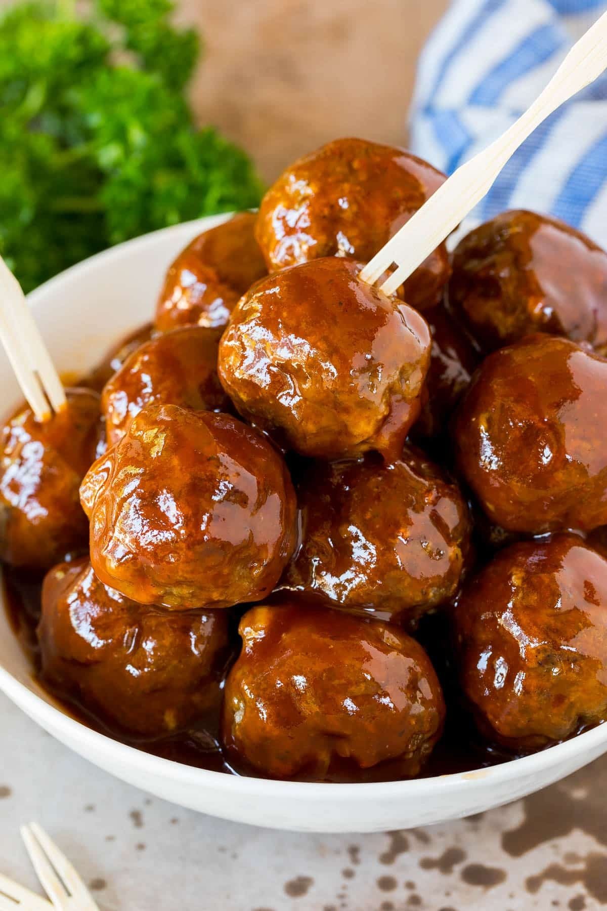 A bowl of crockpot BBQ meatballs with toothpicks in them.
