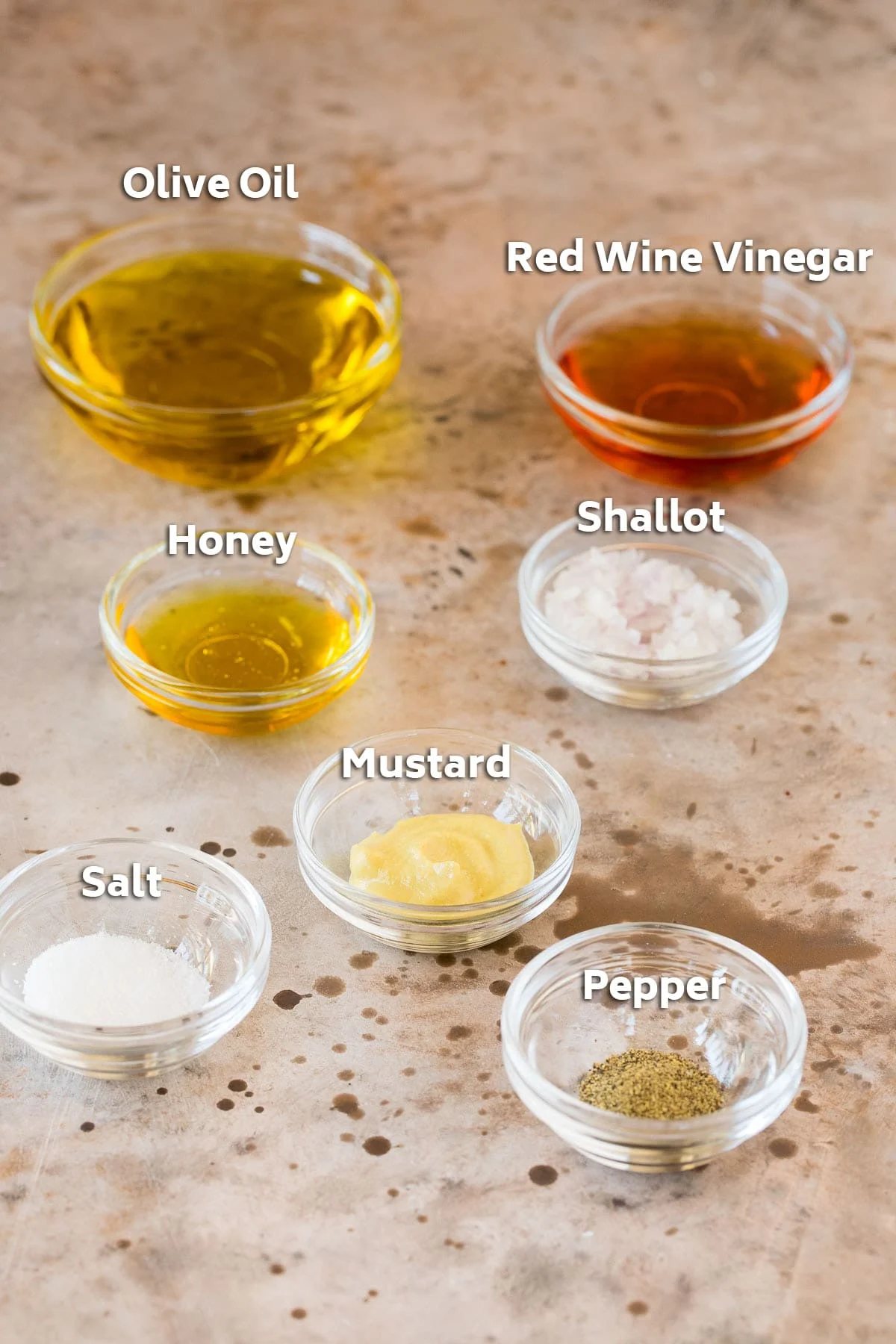 Bowls of dressing ingredients such as olive oil, vinegar and seasonings.