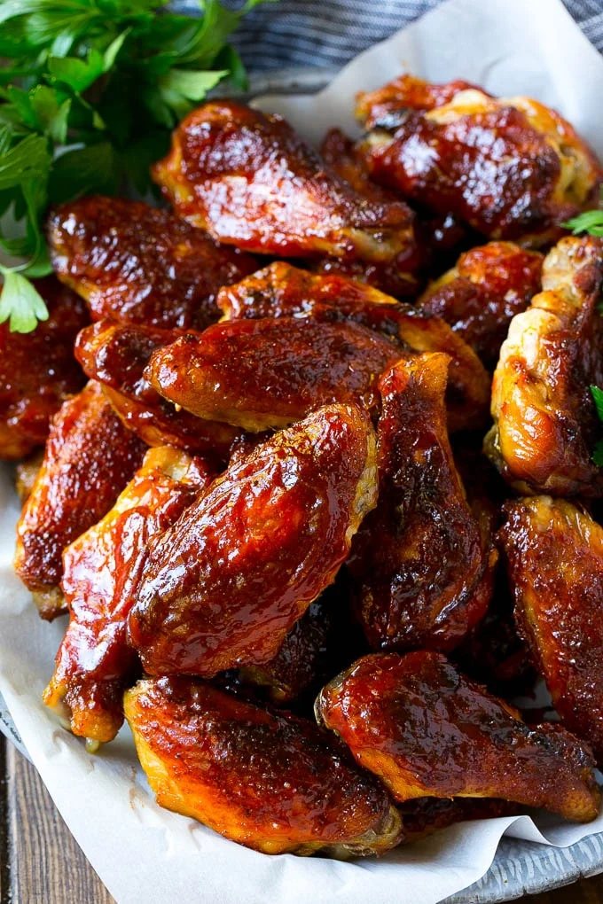 Smoked chicken wings brushed with kitchen-made BBQ sauce on a serving plate.