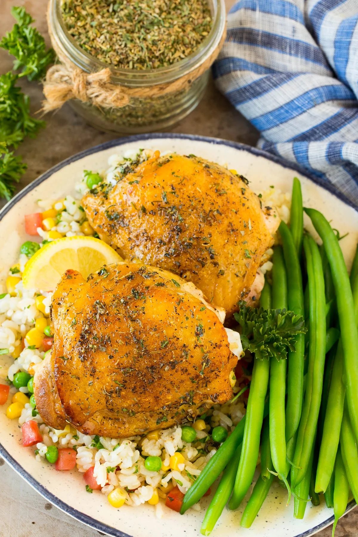 Chicken cooked with Greek seasoning served alongside rice and green beans.