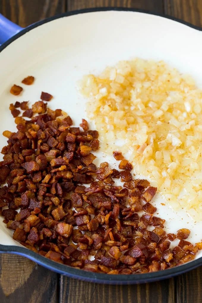 Cooked bacon and sauteed onions in a skillet.