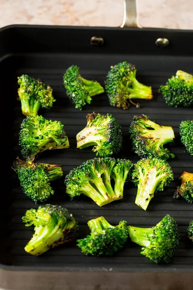 Broccoli florets on a grill pan.