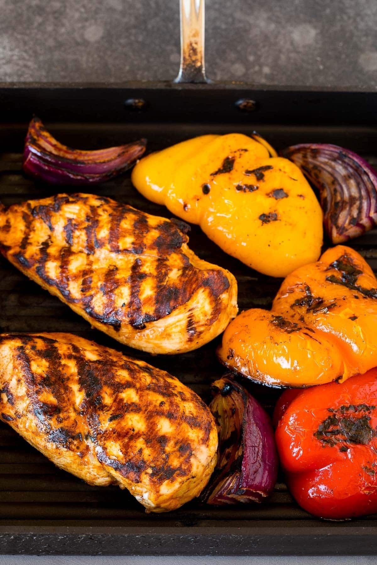 Chicken, bell peppers and onions on a grill pan.