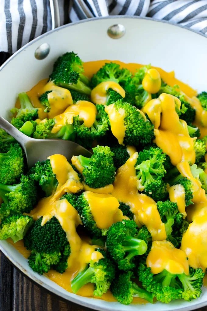 A pan of broccoli with cheese sauce that's full of steamed broccoli florets and kitchen-made sauce.