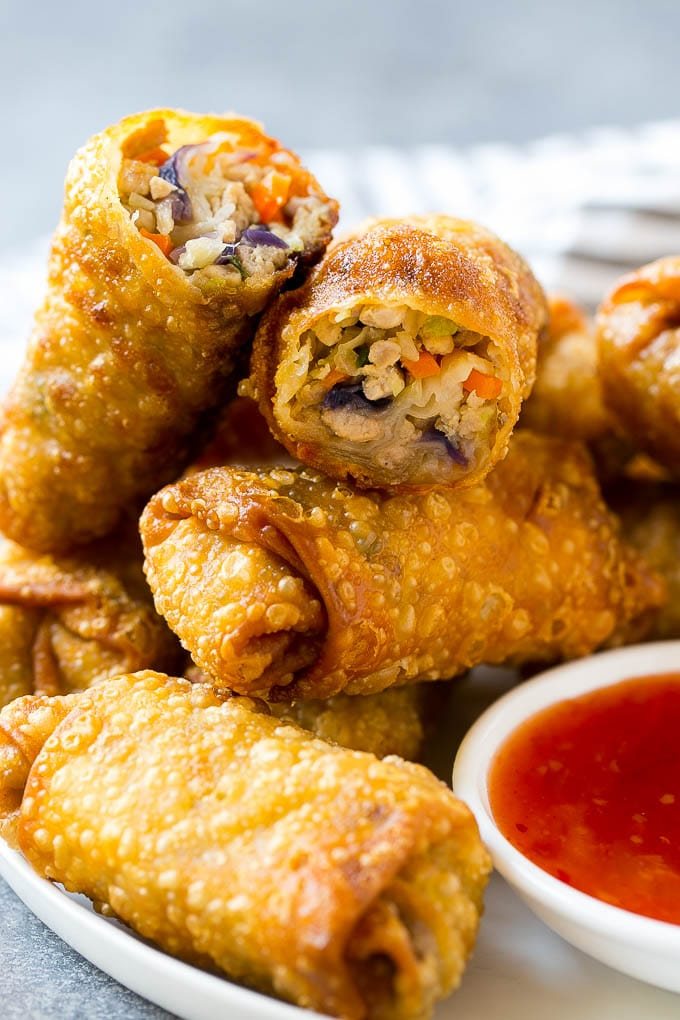 A plate of kitchen-made egg rolls with dipping sauce.