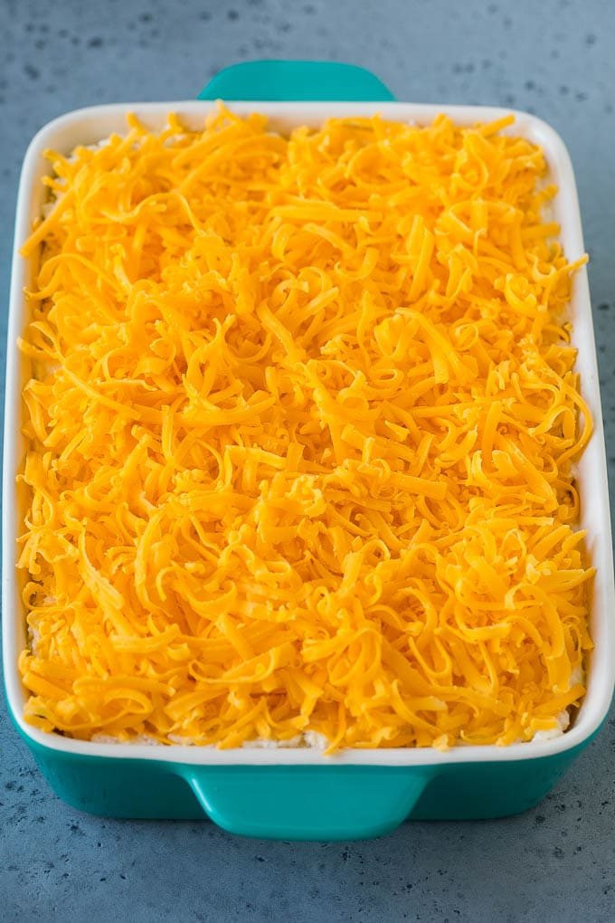 A shredded potato dish covered with shredded cheddar cheese!
