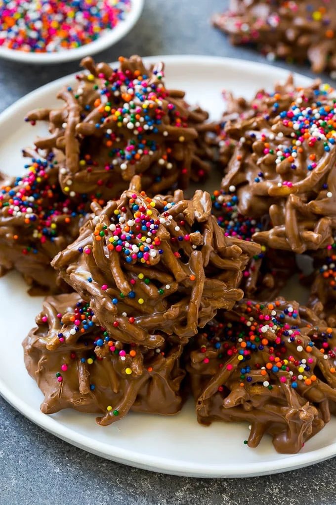 A plate of haystack cookies topped with rainbow sprinkles.