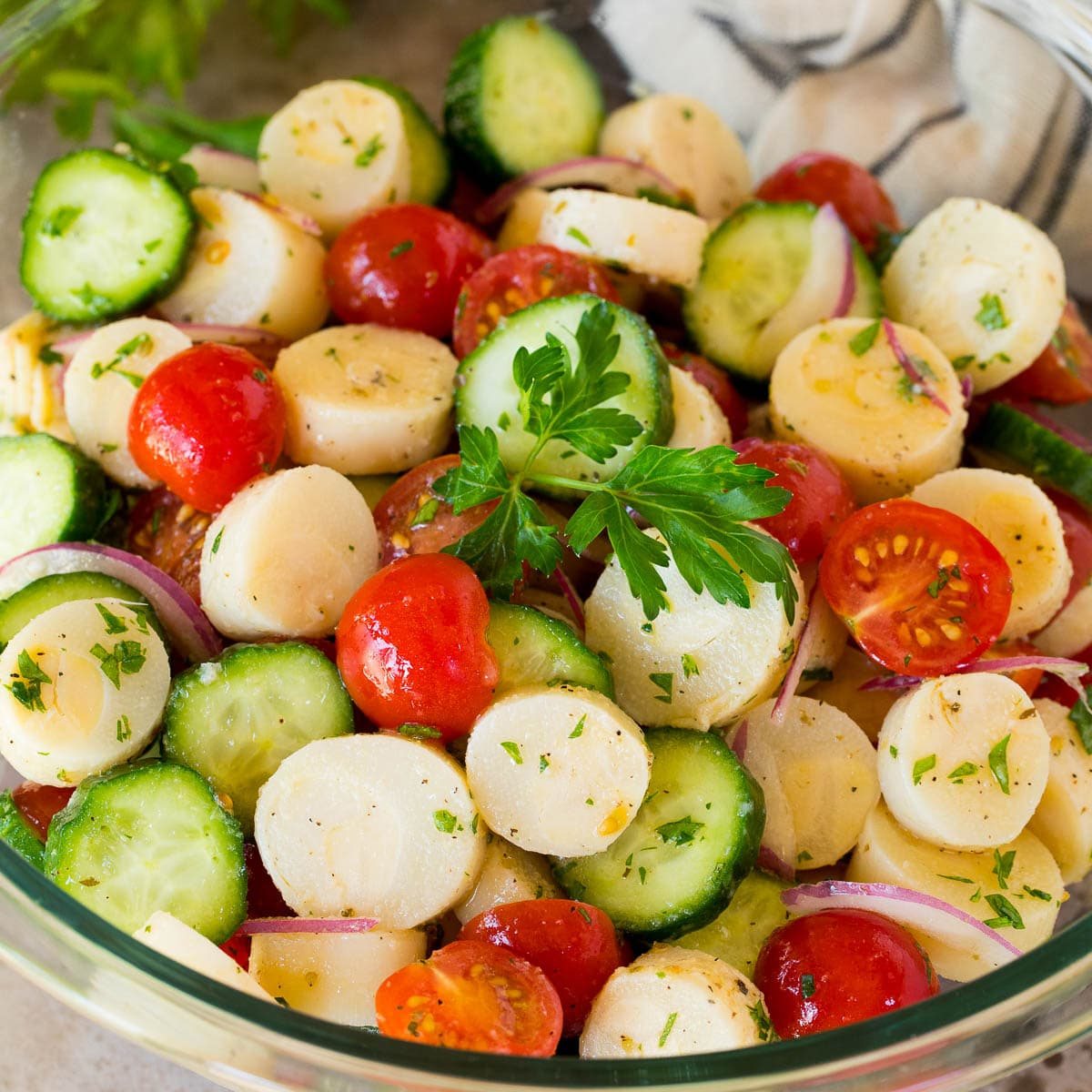 A bowl of hearts of palm salad with parsley on top.