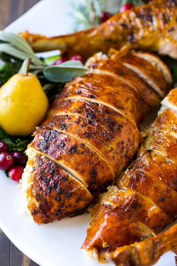 Herb roasted turkey sliced on a platter is the perfect holiday main course.