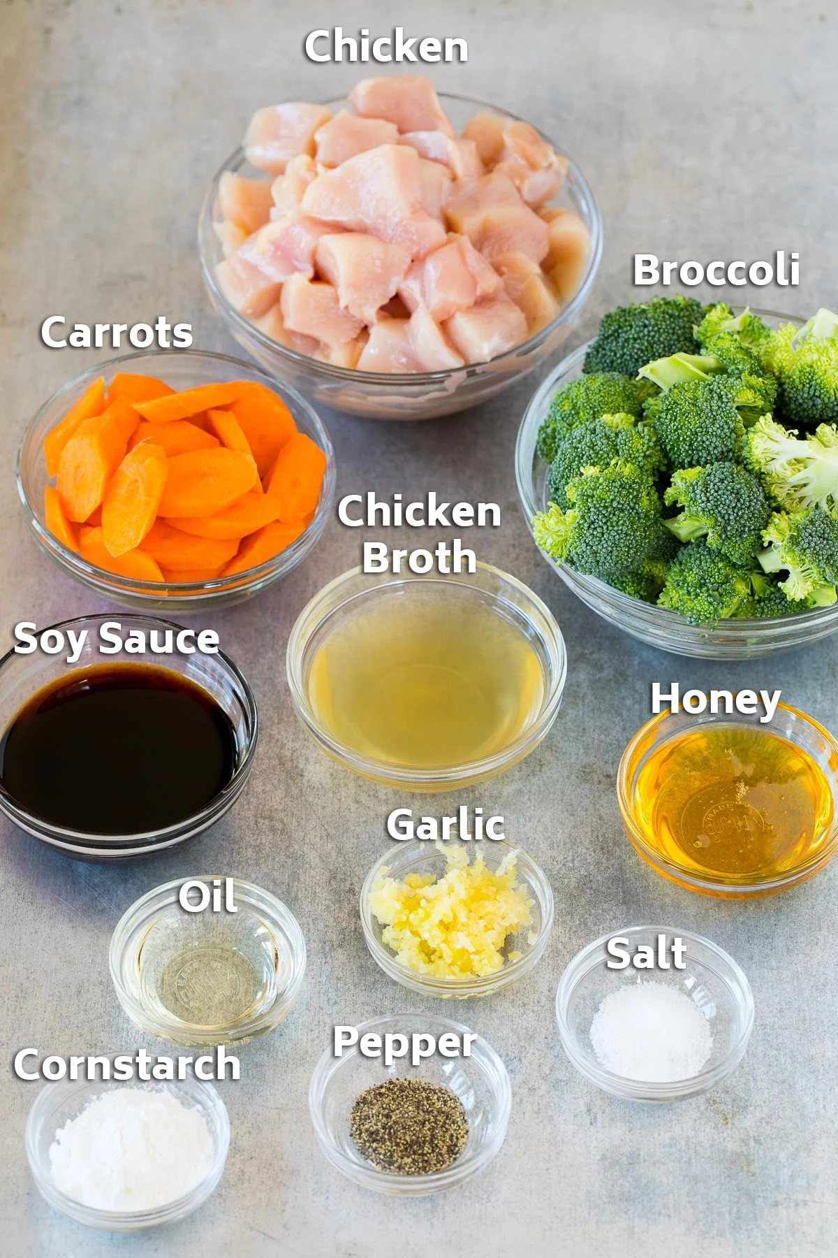 Bowls of ingredients including chicken, vegetables, garlic and soy sauce.