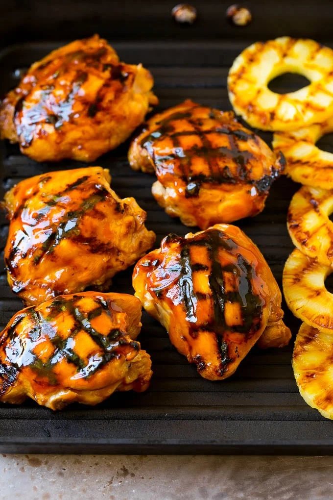 Poultry and pineapple slices on a grill pan.