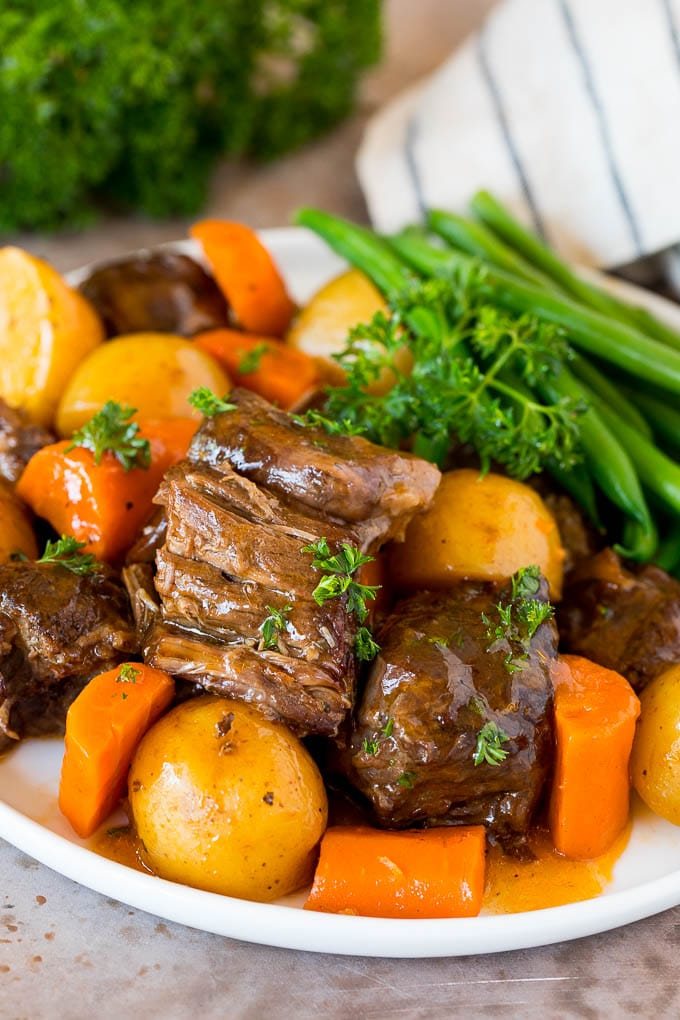 A plate of Instant Pot pot roast served with carrots, green beans and potatoes.