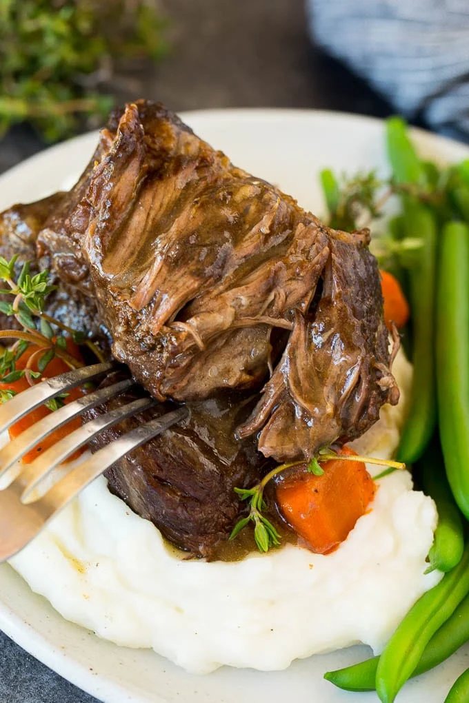 A plate of Instant Pot short ribs served over mashed potatoes.