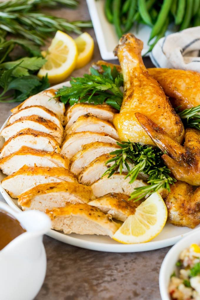 An Instant Pot whole chicken that's been sliced and arranged on a serving plate.