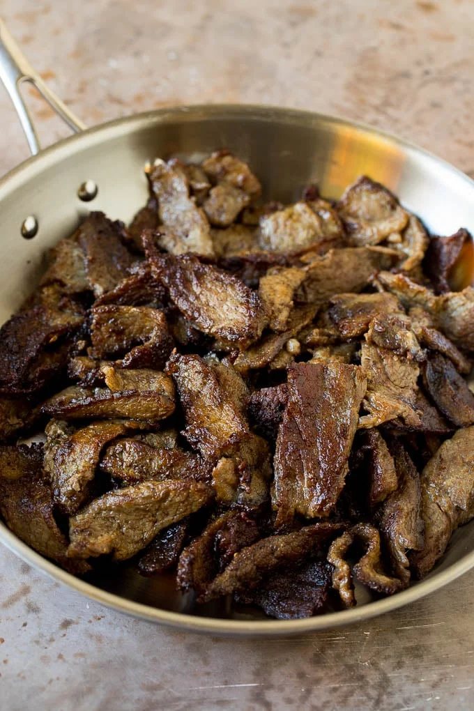 Cooked sliced beef in a skillet.