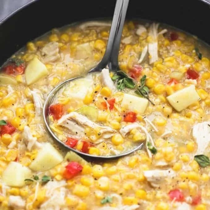 An image of a ladle in a pot of turkey corn chowder.