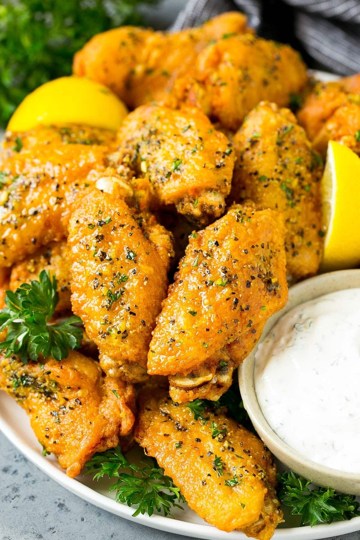 A plate of lemon pepper wings served with ranch.