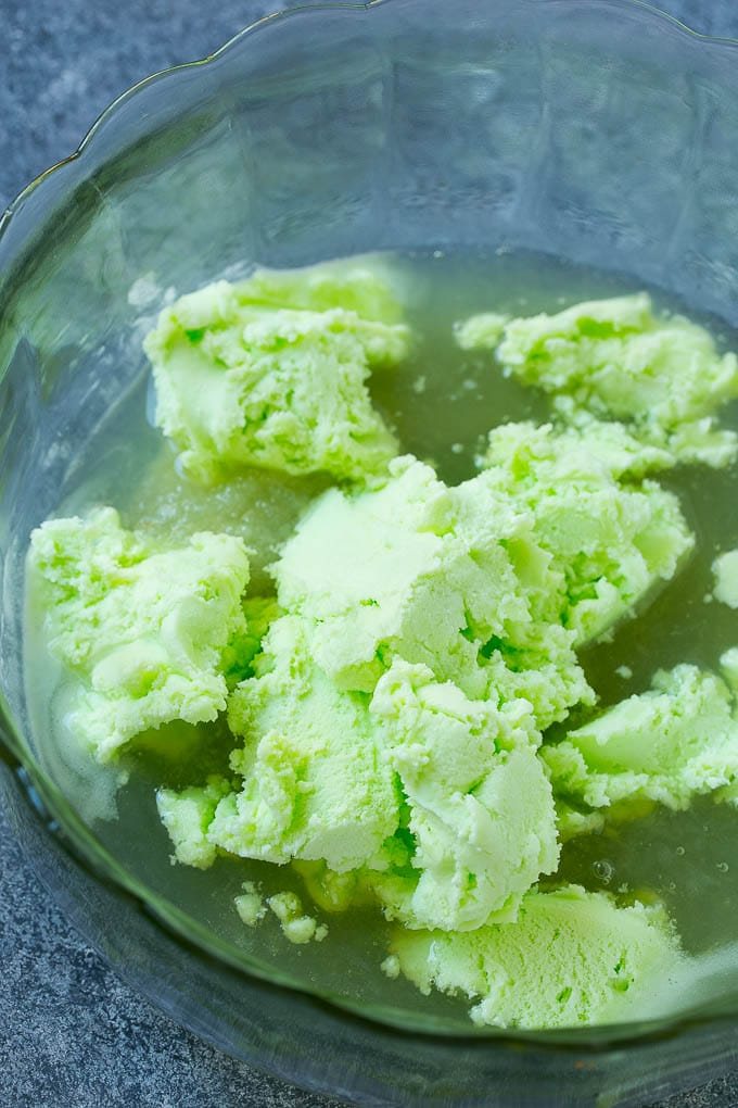A bowl with limeade concentrate and sherbet in it.
