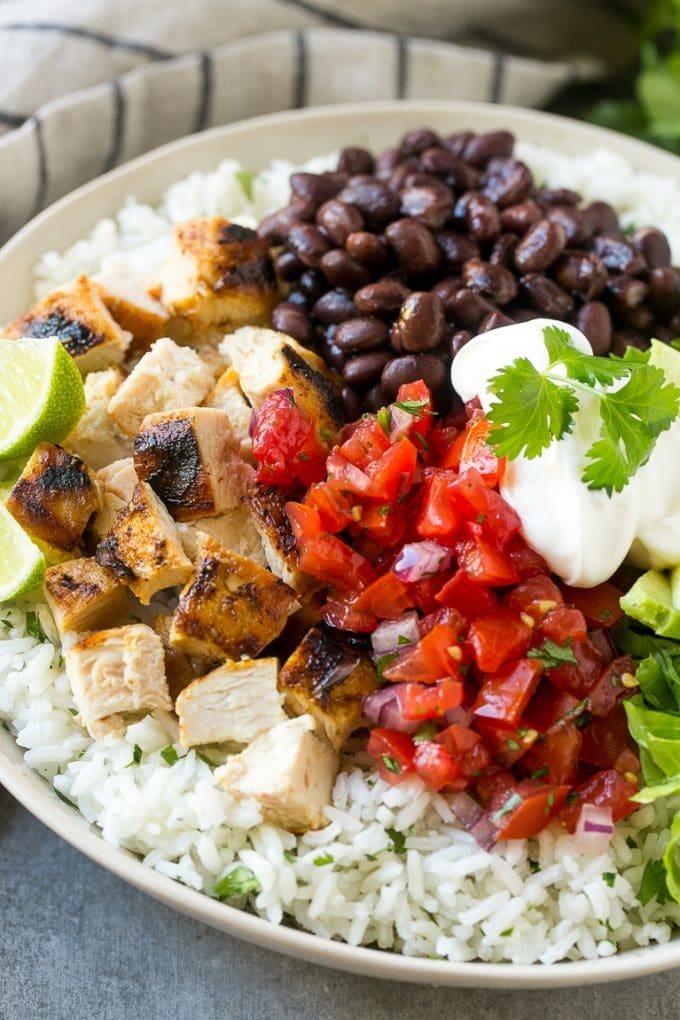 These burrito bowls are loaded with marinated grilled chicken, cilantro lime rice, black beans and a variety of fun toppings. This recipe will become a dinner time staple at your house!