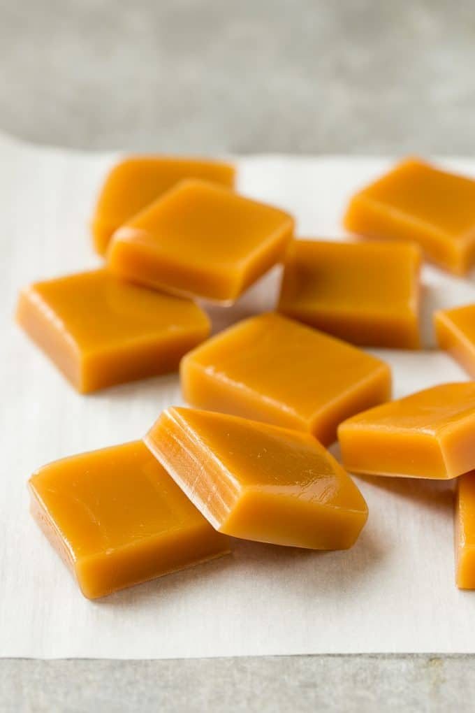 Squares of cooked caramel on parchment.