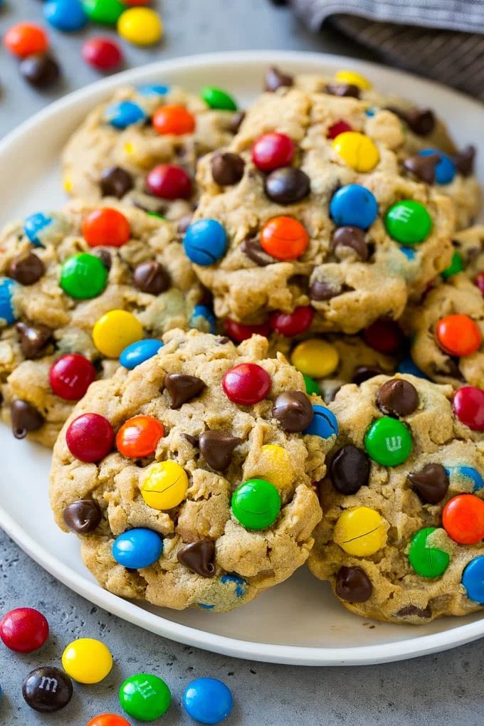 A plate of monster cookies which are made with oats, peanut butter, chocolate chips and M&M's.