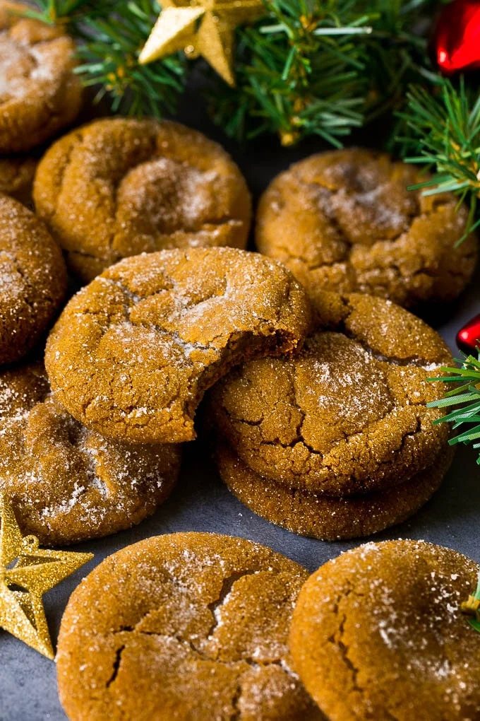 Molasses cookies coated in sugar, surrounded by holiday decorations.
