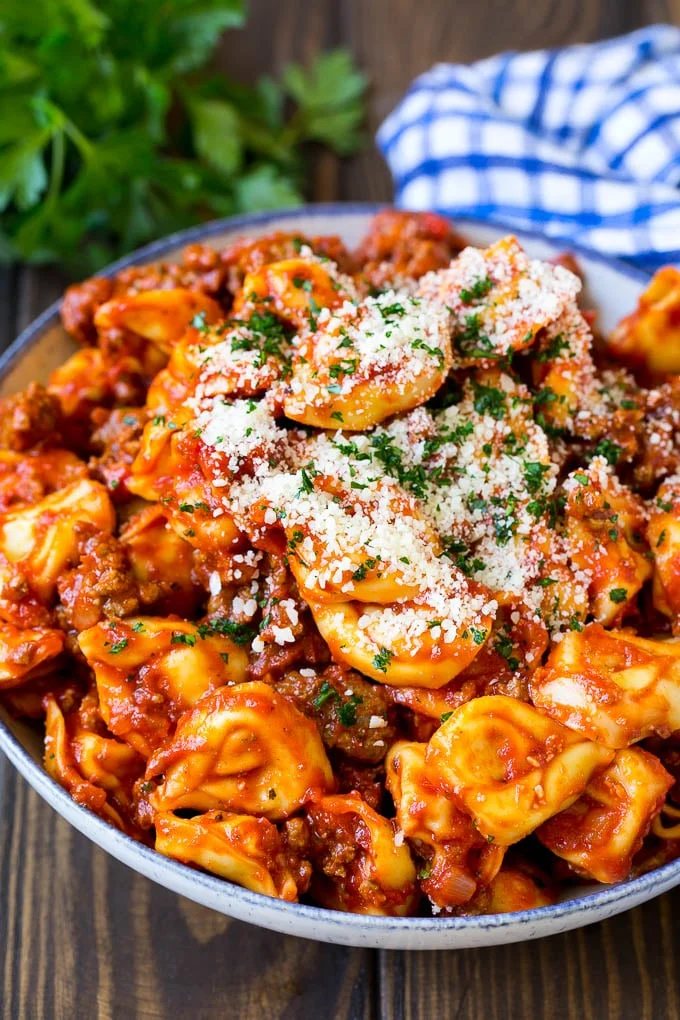 Cheese tortellini in kitchen-made meat sauce, topped with parsley and parmesan cheese.